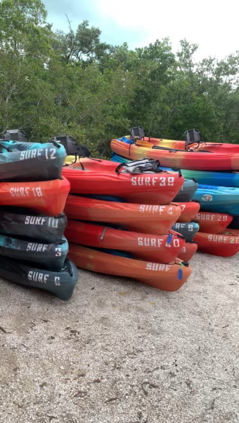 stacked kayaks on the shore