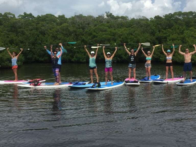 lots of women on stand up paddleboards in a row